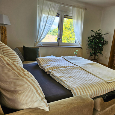 Bettcouch in der Ferienwohnung Hanfdell, mit einem Griff ausgeklappt und zum vollwertigen 1,40 m breiten Bett für zwei Personen umgewandelt