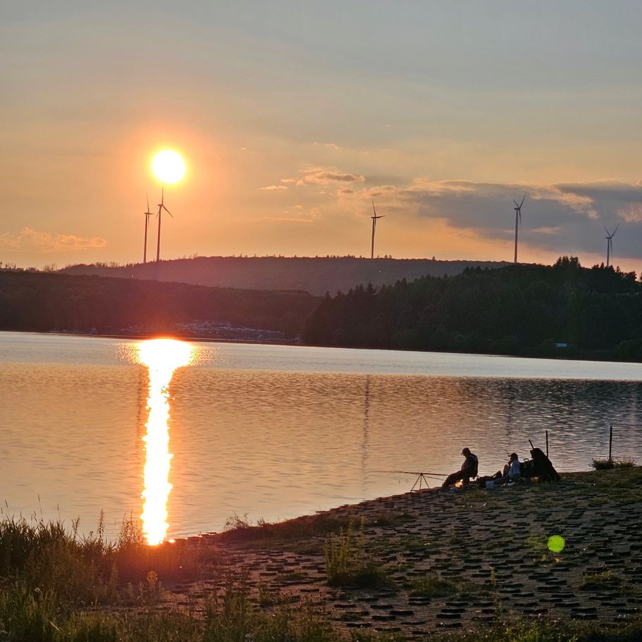 Angeln am Bostalsee in der Abendsonne: Angler beim Ansitzen am Seeufer nahe der Ferienwohnungen Schwarzhof im Saarland.