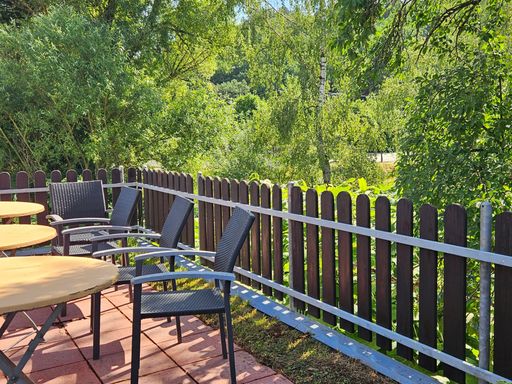 Terrasse des Ferienhauses am Gestüt Nahetal mit Sitzmöbeln und Blick ins Grüne