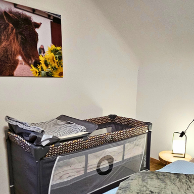 Schlafzimmer der Ferienwohnung Hahnekräh mit optionalem Babyreisebett und Wickelauflage.