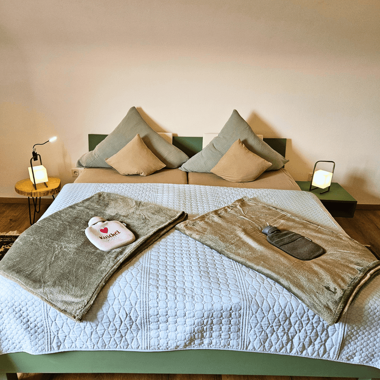 Schlafzimmer Fewo Hahnekräh Bostalsee Doppelbett in beruhigendem Grünton, kuschelige Wintertextilien,naturnahe Holzelemente aus eigenem Wald