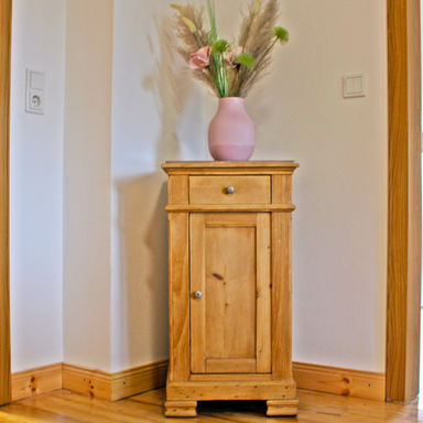 Antikes Schränkchen im Esszimmer der Fewo Hanfdell mit  Blumenstrauß, liebevoll dekoriertes Detail für eine gemütliche Atmosphäre