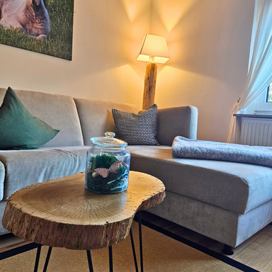 Eckcouch in der Ferienwohnung Hanfdell mit gemütlichem Licht, handgefertigter Lampe und Tisch aus eigenem Baumbestand für eine warme Wohnatm