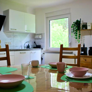 Küchentisch in der Ferienwohnung Hahnekräh mit Küchenzeile und Fenster, Ausblick ins Grüne.