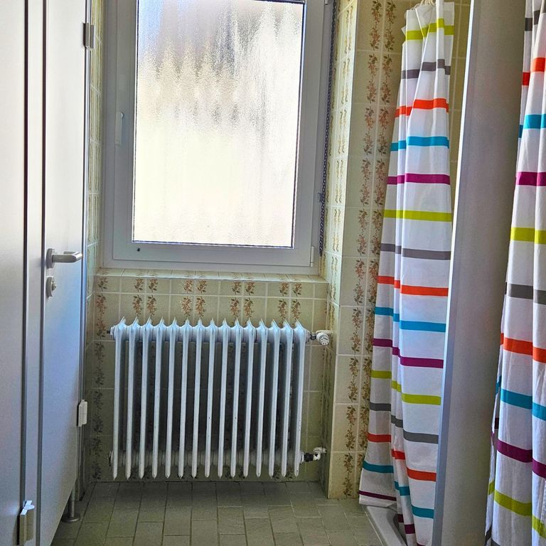 Badezimmer der Ferienwohnung Hahnekräh mit Tageslicht, vielen Ablageflächen, Handtüchern, Pflegeprodukten und leicht erhöhter Toilette.