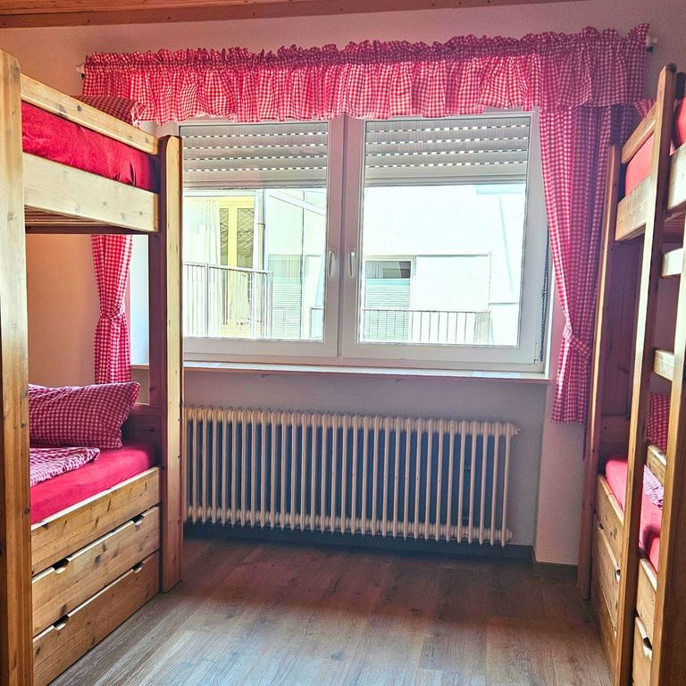 Schlafzimmer Fewo Hahnekräh Bostalsee Doppelbett in beruhigendem Grünton, kuschelige Wintertextilien,naturnahe Holzelemente aus eigenem Wald