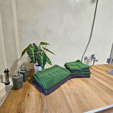 Badezimmerdetail der Ferienwohnung Hahnekräh Ablagefläche mit Hand- und Duschtüchern, Shampoo und Duschgel 